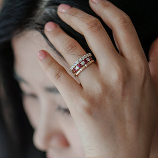 Hand with natural ruby and natural diamond bands pulling hair back.