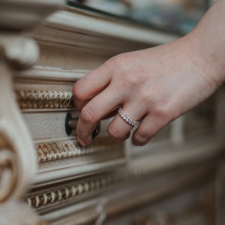 Hand with diamond wedding ring pulling the handle of an antique drawer.
