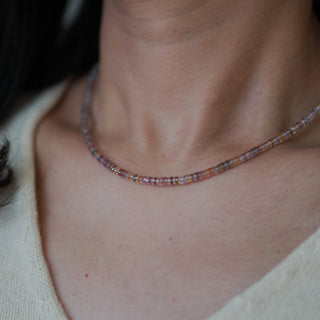 Multicolor sapphire necklace on neck.