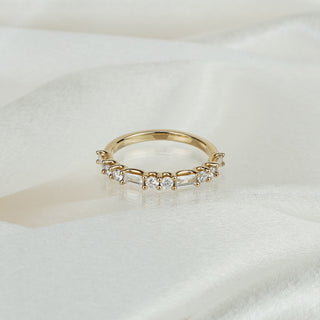 Lab grown diamond alternating baguette and round brilliant wedding band in yellow gold on satin fabric, shared prong stones across the front.