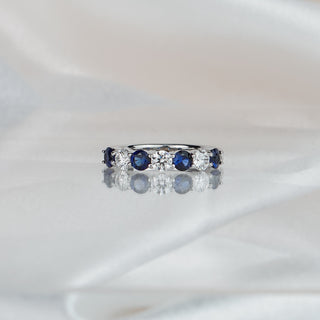White gold band with four natural Ceylon blue Sapphires alternating three Diamonds, wide stone row across the front.