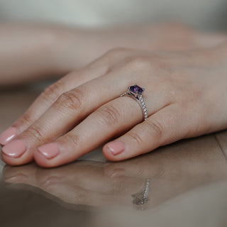 Natural Asscher cut purple Sapphire ring worn on the hand, violet center above a Diamond pavé shank.