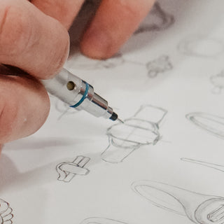 Ring design sketch beside a CAD model on screen at the studio.