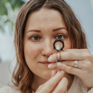 Jewelry designer examining a loose Diamond at the Atelier Fine Co. studio in Vancouver.