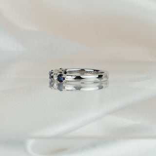 Side view of a Ceylon blue Sapphire and Diamond wedding band in platinum, stones tapering to a 2.7mm band.
