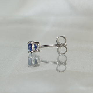 Side view of blue Sapphire stud earrings showing white gold posts, friction backs, and four-prong baskets.
