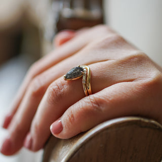 Yellow gold shadow band worn stacked beneath a pear cut engagement ring, curve sitting flush against the setting.