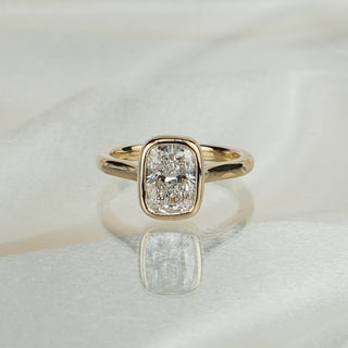 Yellow gold solitaire with a 2.06 carat cushion cut lab diamond in a full bezel, low profile above the finger.