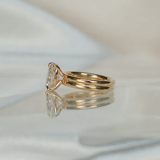 Side view of a cushion double shank engagement ring, the split between the two bands visible below the basket.