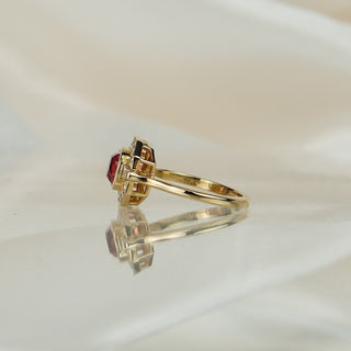 Side view of a pink Spinel geometric engagement ring, milgrain frame edge and slim yellow gold shank visible.