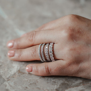 Four diamond bands on hand showing different sizes of diamond carat weights.