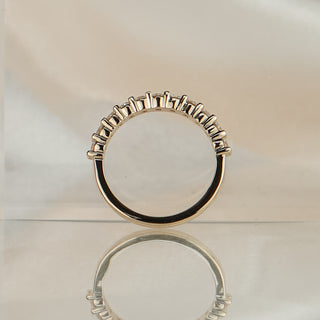 Video of a yellow gold lab grown diamond half eternity band worn on the hand, shared claw stones catching light in motion.