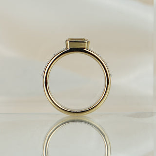 Emerald cut yellow Diamond two-tone ring standing upright with reflection, bezel profile above the stacked shank.