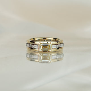 Two-tone engagement ring with a 1.00 carat emerald cut natural yellow Diamond, white and yellow gold bands stacked in a triple shank.