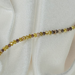Beaded necklace with multicolored beads on a white fabric background