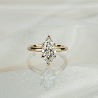 Yellow gold solitaire with a 2.04 carat marquise cut lab grown diamond, ornate flower head prongs at each point.