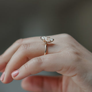 Marquise cut lab diamond solitaire worn on the hand, flower head crown lifting the stone in yellow gold.