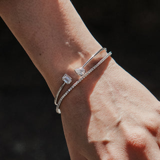 Yellow gold bangle bracelet with Diamonds worn on the wrist.
