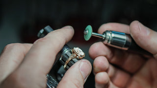 Bench jeweler sanding a Diamond engagement ring after stone setting at the Vancouver studio.