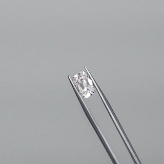 Loose diamond held in tweezers for inspection.