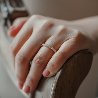 Scallop shared claw lab diamond band worn on the hand, slim 2.5mm stone row in warm gold.