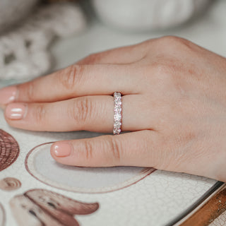 Lab diamond half eternity band in white gold worn on the finger, scallop set stones in a row across the front.