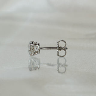 Side view of lab diamond stud earrings showing white gold posts, friction backs, and four-prong baskets.