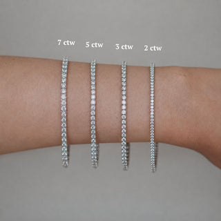 Four widths of white gold lab diamond tennis bracelets worn on the wrist, size comparison across 2, 3, 5, and 7 ctw.