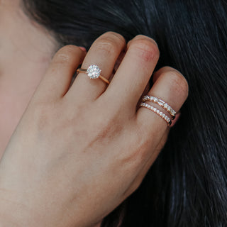 Yellow gold alternating cut band worn stacked beneath a solitaire engagement ring, baguettes and rounds in a row.