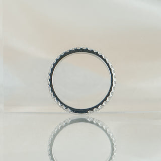 Micro pavé lab grown diamond band standing upright with reflection, stone coverage running nearly the full circle.