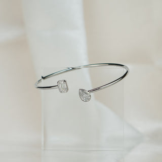 Toi et moi lab diamond bangle standing upright on soft fabric, showing the open cuff profile in white gold.