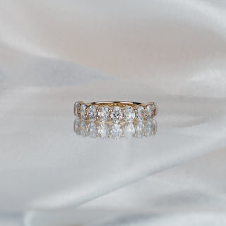 Yellow gold band with eleven oval cut lab grown diamonds in shared prongs, 4.0mm stone row across the front.