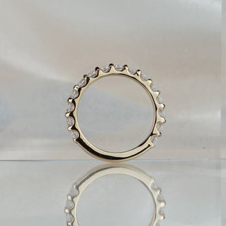Scallop half eternity band standing upright with reflection, U-shaped seats visible beneath each round brilliant.
