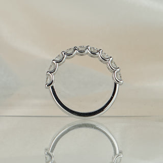 Scallop shared claw half eternity band standing upright with reflection, showing the U-shaped seats under each stone.
