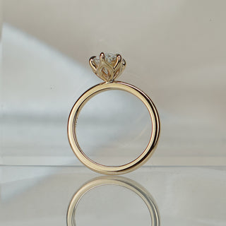 Marquise lab diamond flower head solitaire standing upright with reflection, petal-style crown over a slim yellow gold shank.