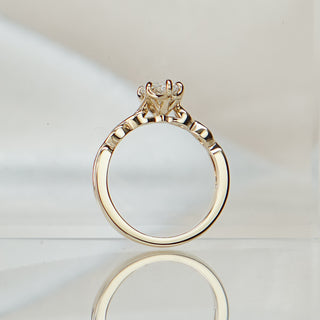 Marquise lab diamond engagement ring standing upright with reflection, braided yellow gold shank in full view.