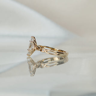 Side view of a marquise braided shank engagement ring, woven band texture rising to the prong basket.