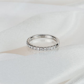 Lab grown diamond micro pavé half eternity band in white gold on satin fabric, fifteen small round brilliants across the front.