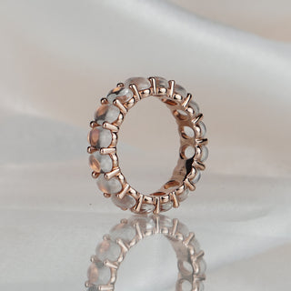 Moonstone full eternity ring standing upright with reflection, oval stones circling the full band with no plain back.