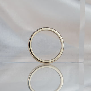 Micro pavé natural Diamond wedding band standing upright with reflection, slim yellow gold profile in frame.