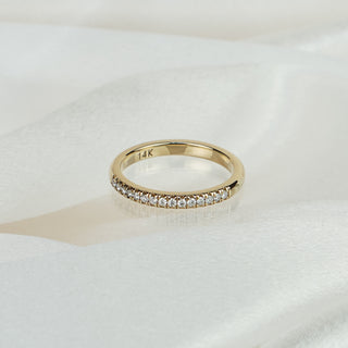 Natural Diamond micro pavé wedding band in 14k yellow gold on satin fabric, 14K hallmark visible inside the band.