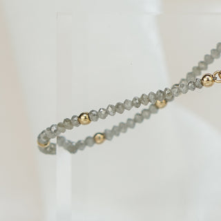 Grey raw faceted Diamond bracelet doubled on an acrylic block, 14k yellow gold beads spaced along the strand.