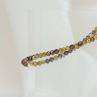 Raw faceted yellow and brown Diamond bracelet stretched across an acrylic block, earthy stones alternating with 14k gold beads.
