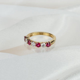 Natural Burmese Ruby and Diamond wedding band in yellow gold on satin fabric, four rubies and three round brilliants in shared claws.