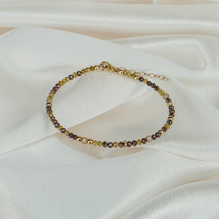 Natural yellow and brown raw faceted Diamond bracelet on white satin fabric, 55 stones with yellow gold beads and clasp visible.