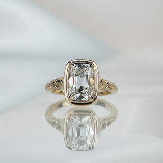 Yellow gold solitaire with a 2.78 carat old mine cushion cut lab diamond, hand-engraved detail along the tapering band.