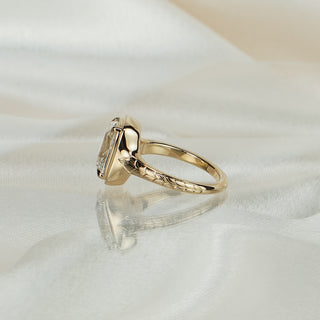 Side view of an old mine cushion engagement ring, cherry blossom engraving on the shank rising to the bezel.