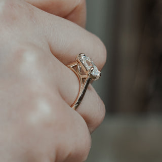 East-west old mine cut solitaire worn on the hand, antique style faceting stretched across the finger in yellow gold.