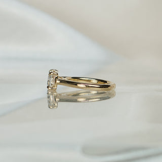 Side view of an east-west old mine cut engagement ring, cathedral shoulders rising to the low-set center.
