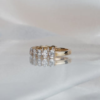 Side view of an oval cut lab diamond wedding band in yellow gold, stones tapering to a slim 2.2mm back.